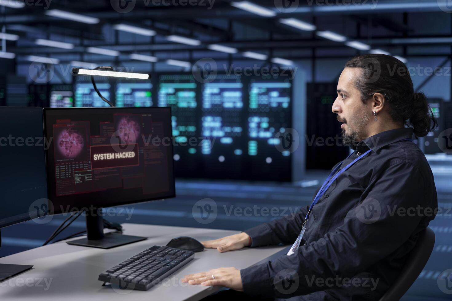 Engineer in server hub frightened by hacker passing company firewall and stealing sensitive user data. Afraid man panicking after seeing security breach notification on computer in data center photo