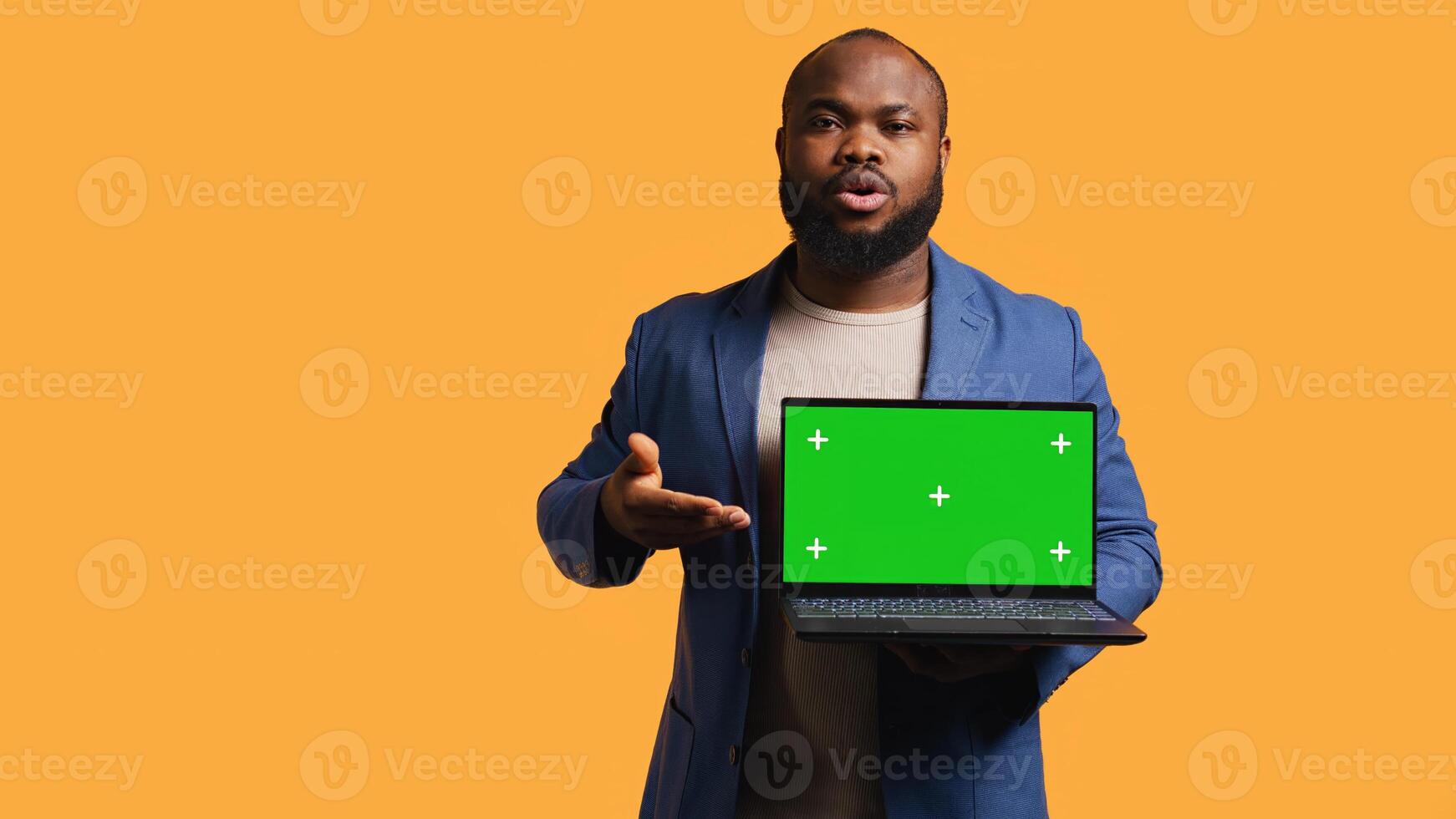 Portrait of african american man doing influencer marketing using green screen lapyop, studio background. BIPOC person holding empty copy space mockup notebook, doing advertising camera B photo
