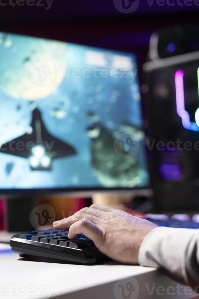 Man at home doing gaming session, destroying enemy spacecrafts to finish level in flying game. Close up of gamer playing SF videogame, shooting asteroids with laser bullets photo