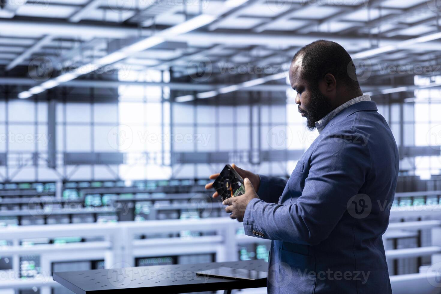 System administrator in data center checking storage units and infrastructure parts, doing checkup. IT expert looking closely at hard drive equipment, planning and executing server hub rigs upgrades photo