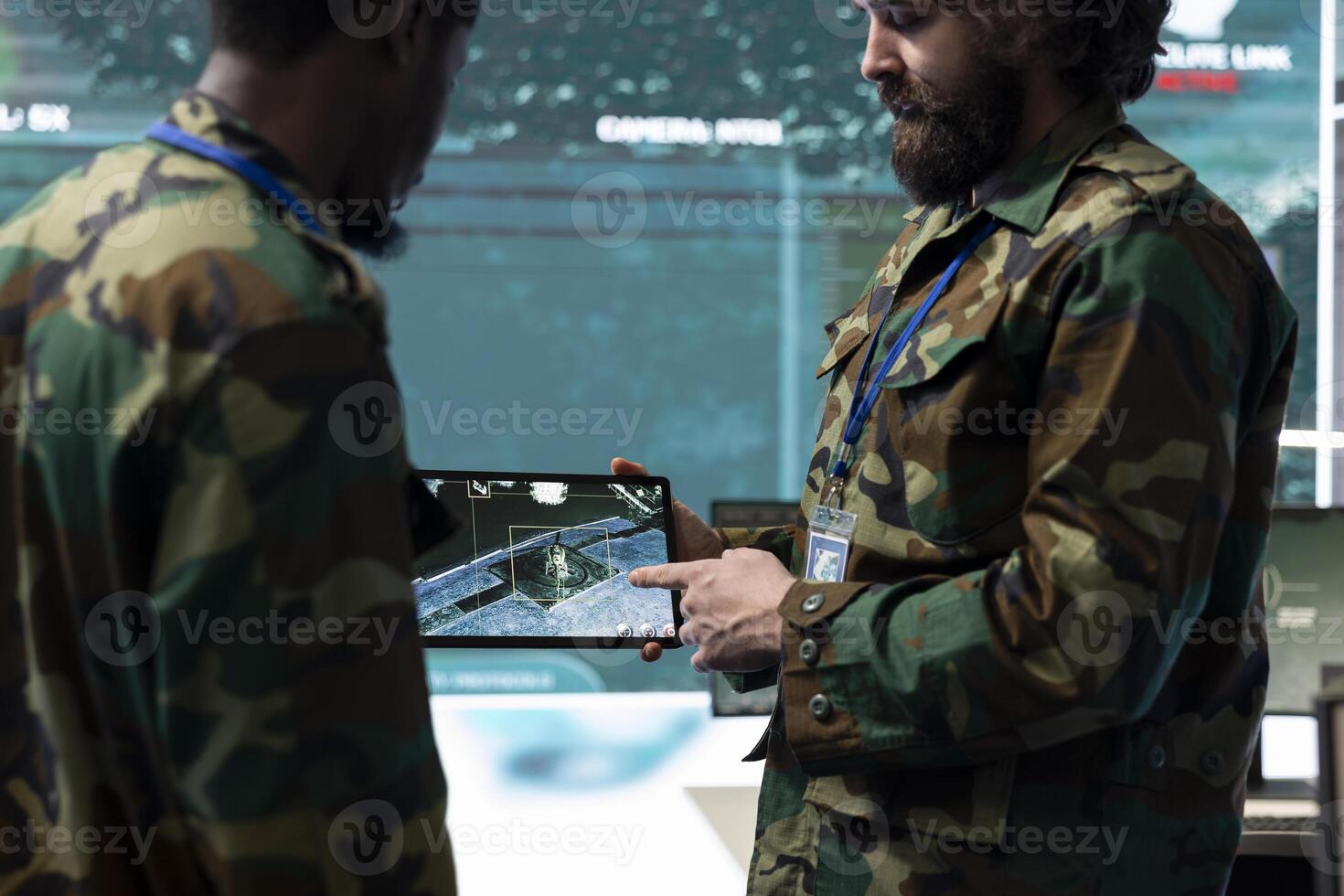 Diverse soldiers team analyzing surveillance CCTV radar imagery on a tablet, collecting real time data for a new mission in command room. Army IT professionals operating high tech gear. photo