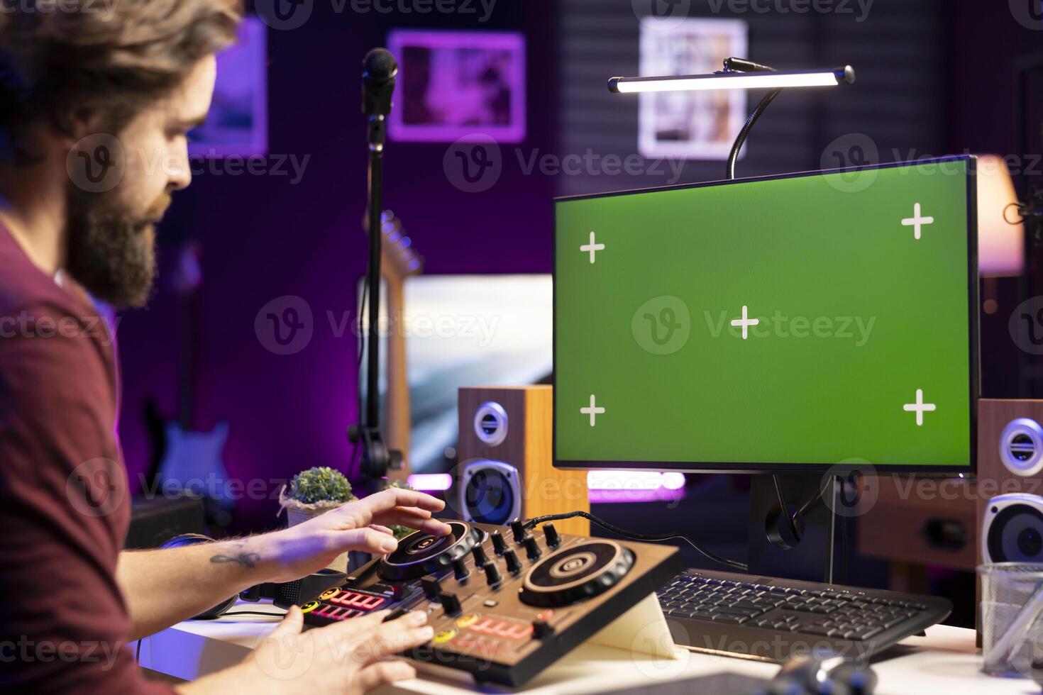 Musician watching online tutorials to learn editing songs on greenscreen, working on post production in home studio. Artist mixing soundtracks and adjusting volume levels. photo