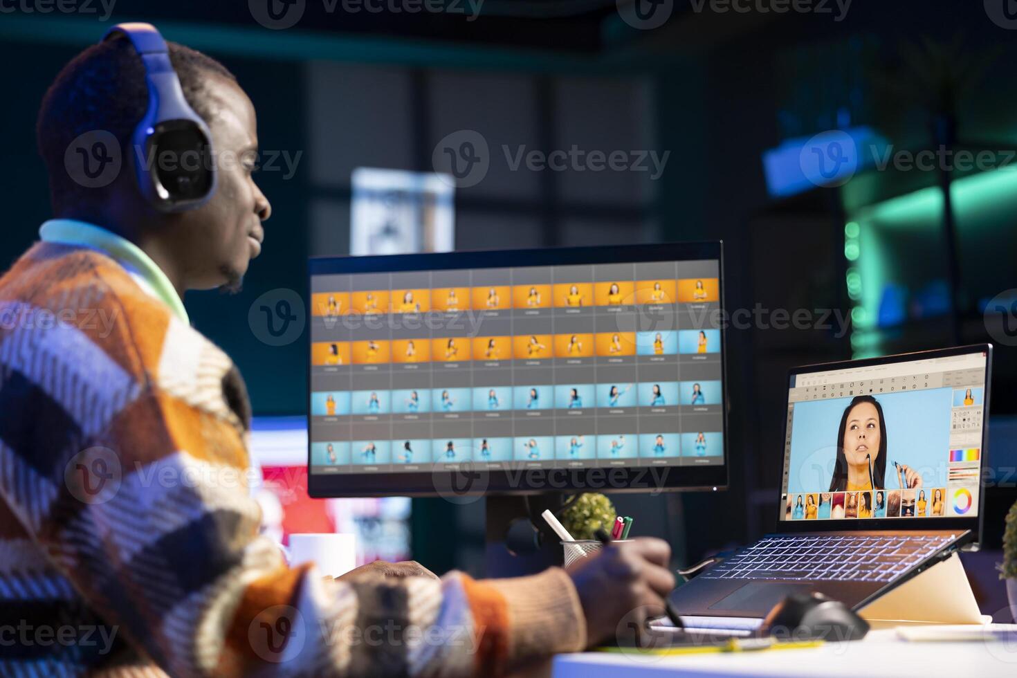 Black man photo editor in a well organized workspace editing images on dual monitors using advanced software tools, displaying creativity and professional dedication. Computer setup.