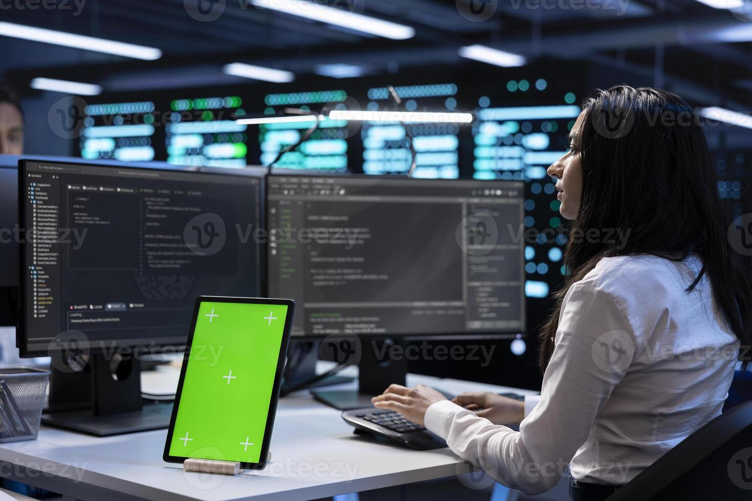 Computer scientists in data center checking equipment performance on green screen tablet after upgrading machines. Admins doing maintenance on rigs in servers room using chroma key device photo