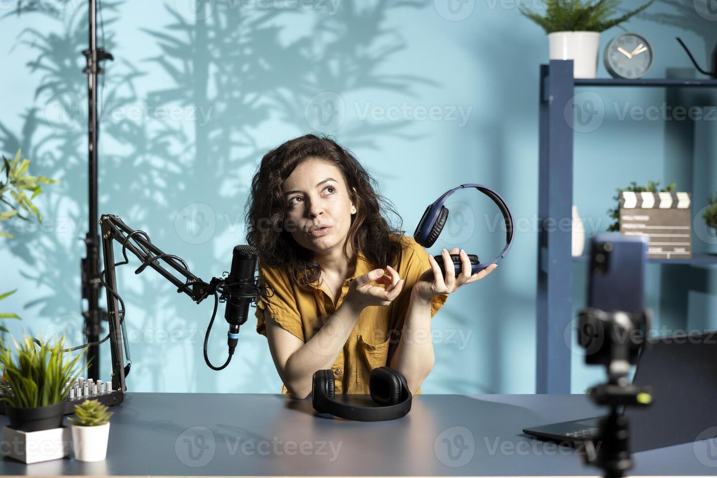 Audiophile reviewing newly launched wireless headphones, testing sound clarity before endorsing them. Tech professional filming internet channel , checking listening device features photo