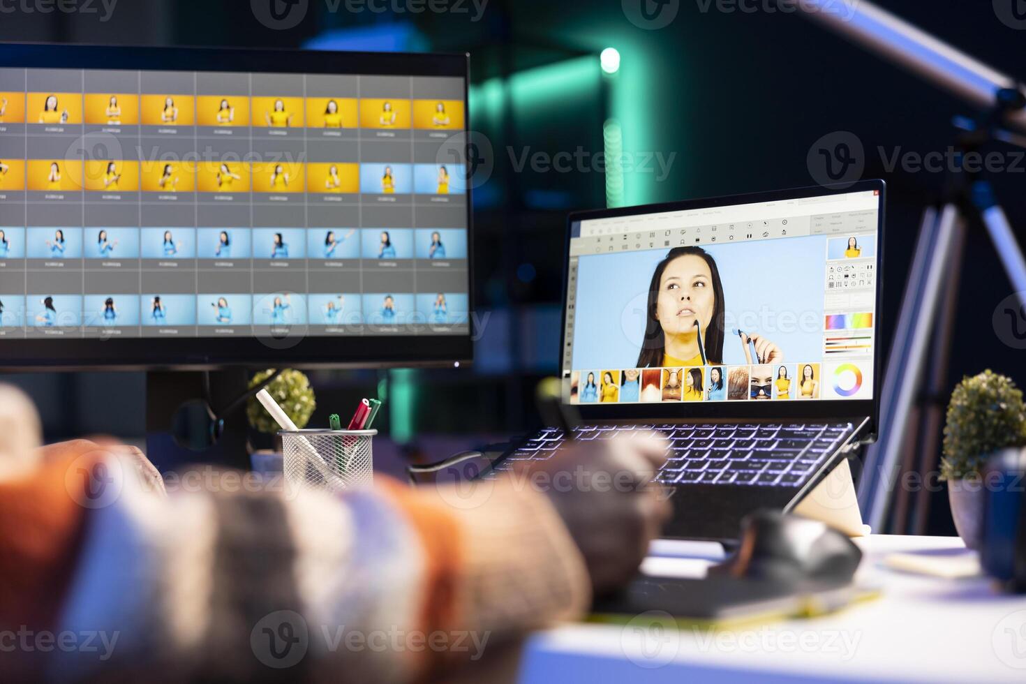 Professional graphic designer retouching images on dual monitors in a creative office environment, demonstrating multitasking skills and innovative techniques. Well organized editor. photo