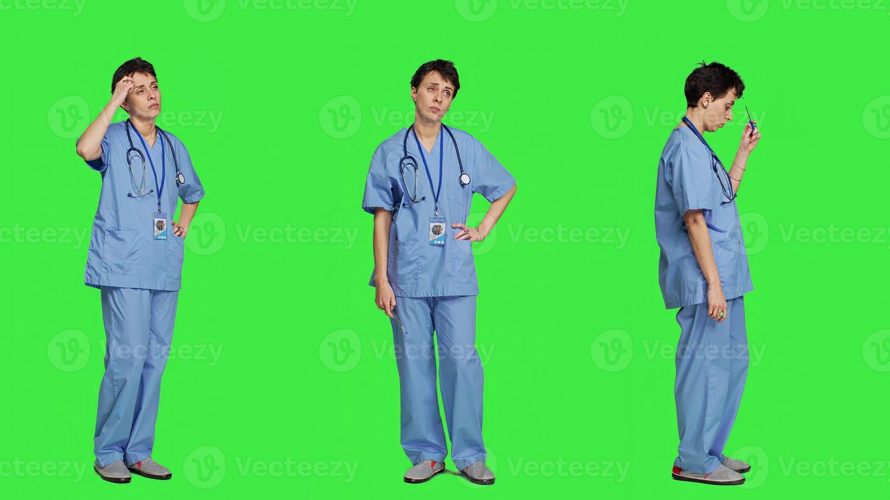 Medical assistant thinking about new treatment ideas in studio, acting thoughtful while she stands against greenscreen backdrop. Pensive young nurse contemplating about healthcare ideas. Camera A. photo