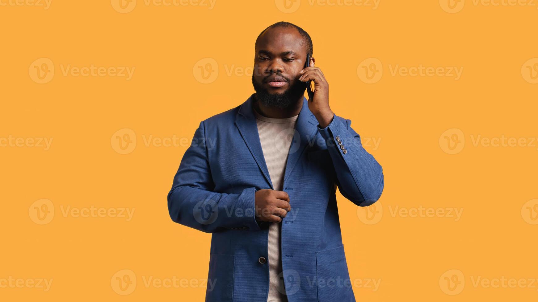 African american man disagreeing with friend during telephone call, shaking head, studio background. BIPOC person talking on phone with mate, unhappy with proposal, refusing, camera B photo