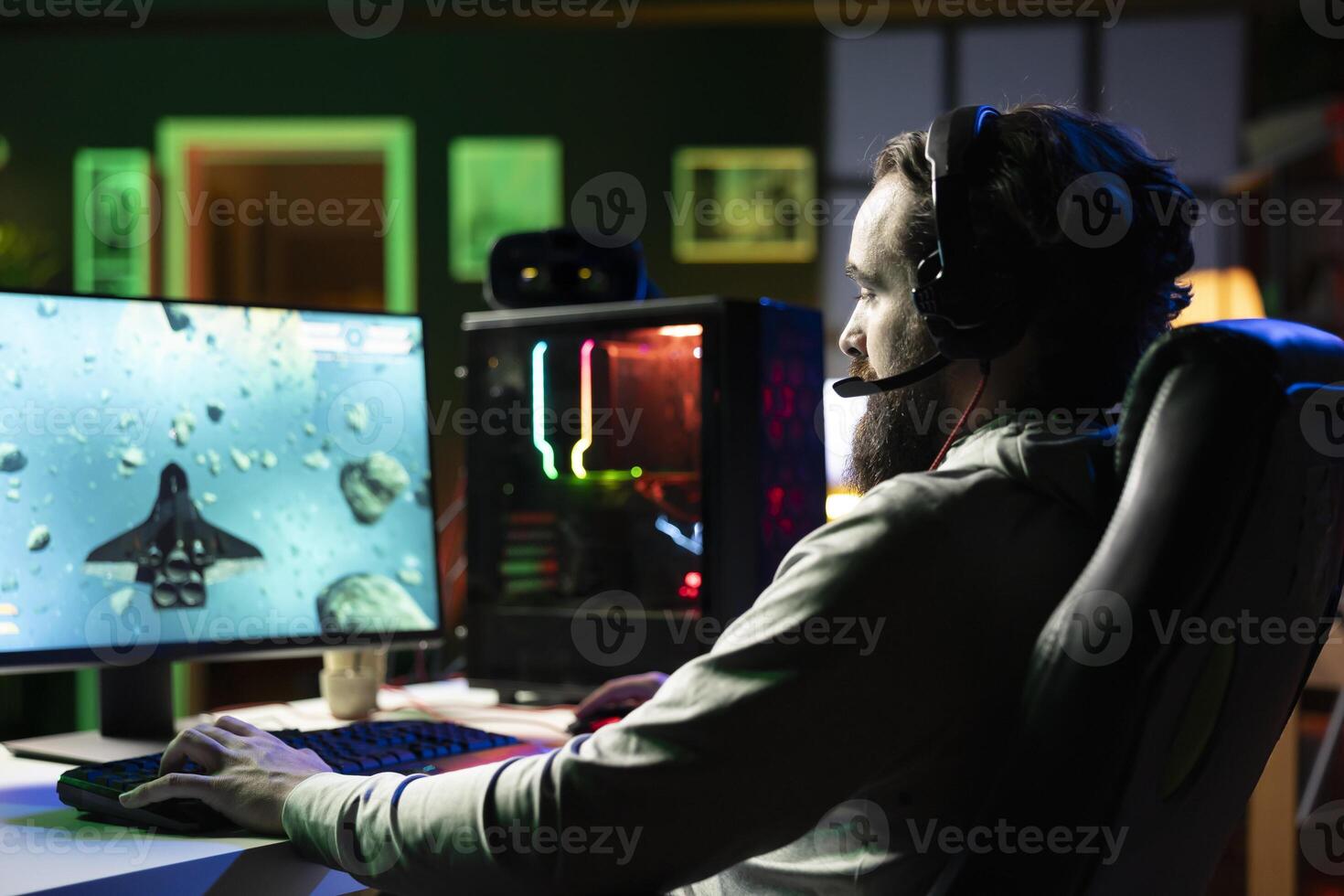 Man plays online multiplayer spaceship videogame with friends, using headphones for immersive experience. Player using gaming setup to flying spacecraft in flight game, enjoying leisure time photo