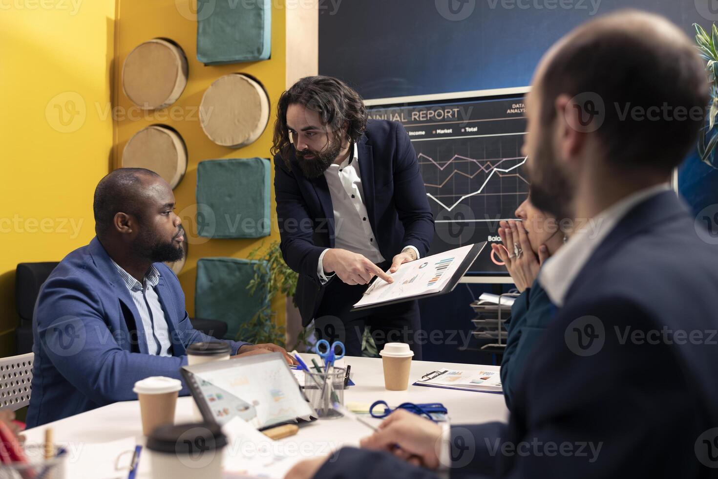 Staff members from a business enterprise discussing insight and details for a new project during a corporate conference. Company employees are getting informed about marketing developments. photo