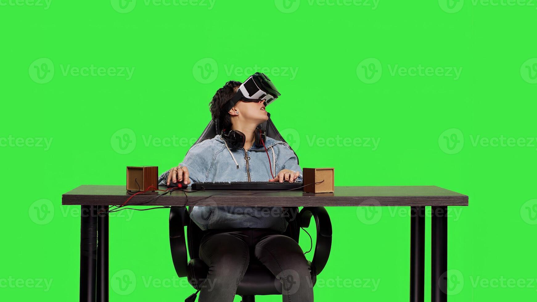 Disappointed player losing at games shooter competition with virtual reality headset, playing contest on computer against greenscreen. Sad frustrated woman being displeased. Camera B. photo