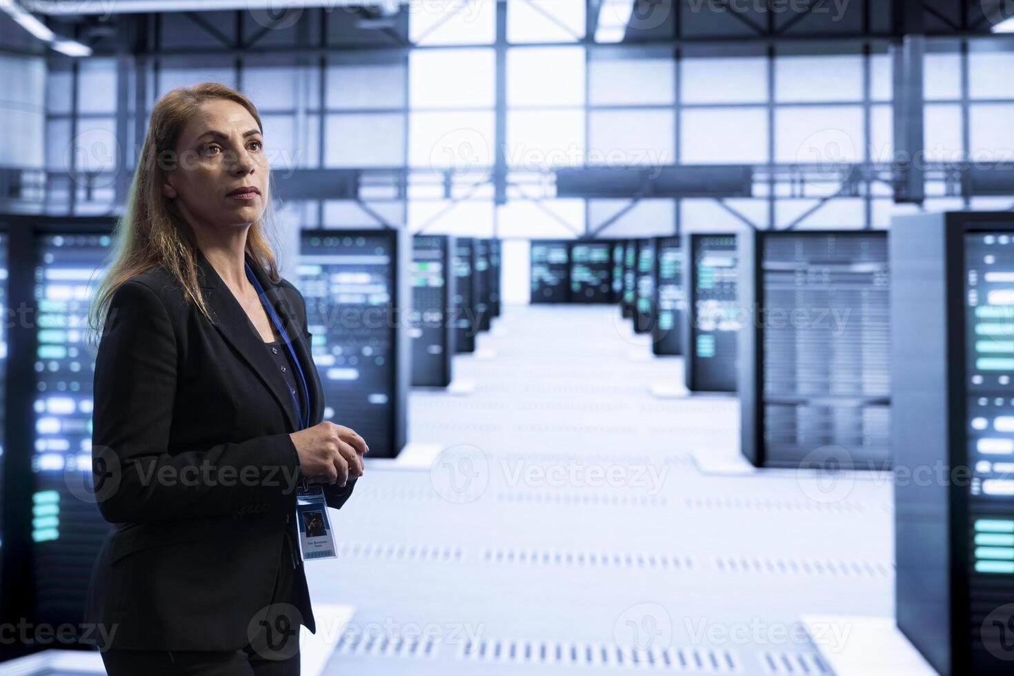 System administrator walking in server hub, checking hardware after installing storage units. Woman in data center doing maintenance after replacing rackmounts components photo