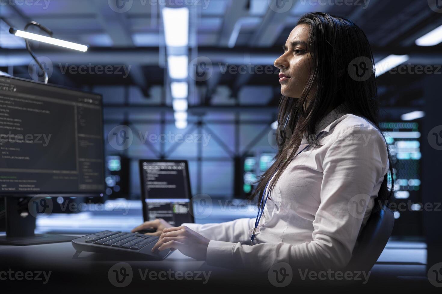 Developer using computer to troubleshoot hardware and software issues in server room. IT professional monitoring and maintaining server and network infrastructure in data center using PC photo