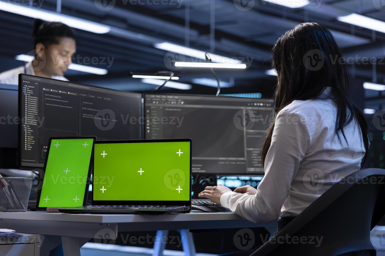 Coworkers in data center using green screen laptop and tablet to find firewall misconfigurations affecting servers. Colleagues in server room checking systems bottlenecks using mockup devices photo