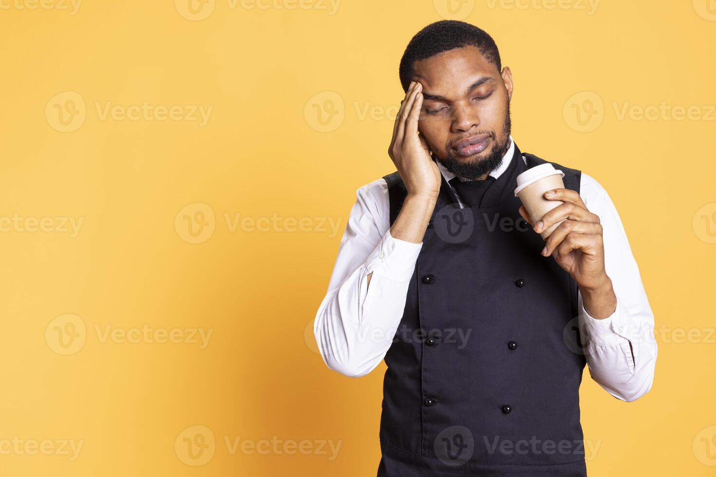 Restaurant employee dealing with a painful headache while he serves clients, carrying a cruet set for excellent customer satisfaction. Unwell waiter working in pain with migraine. photo