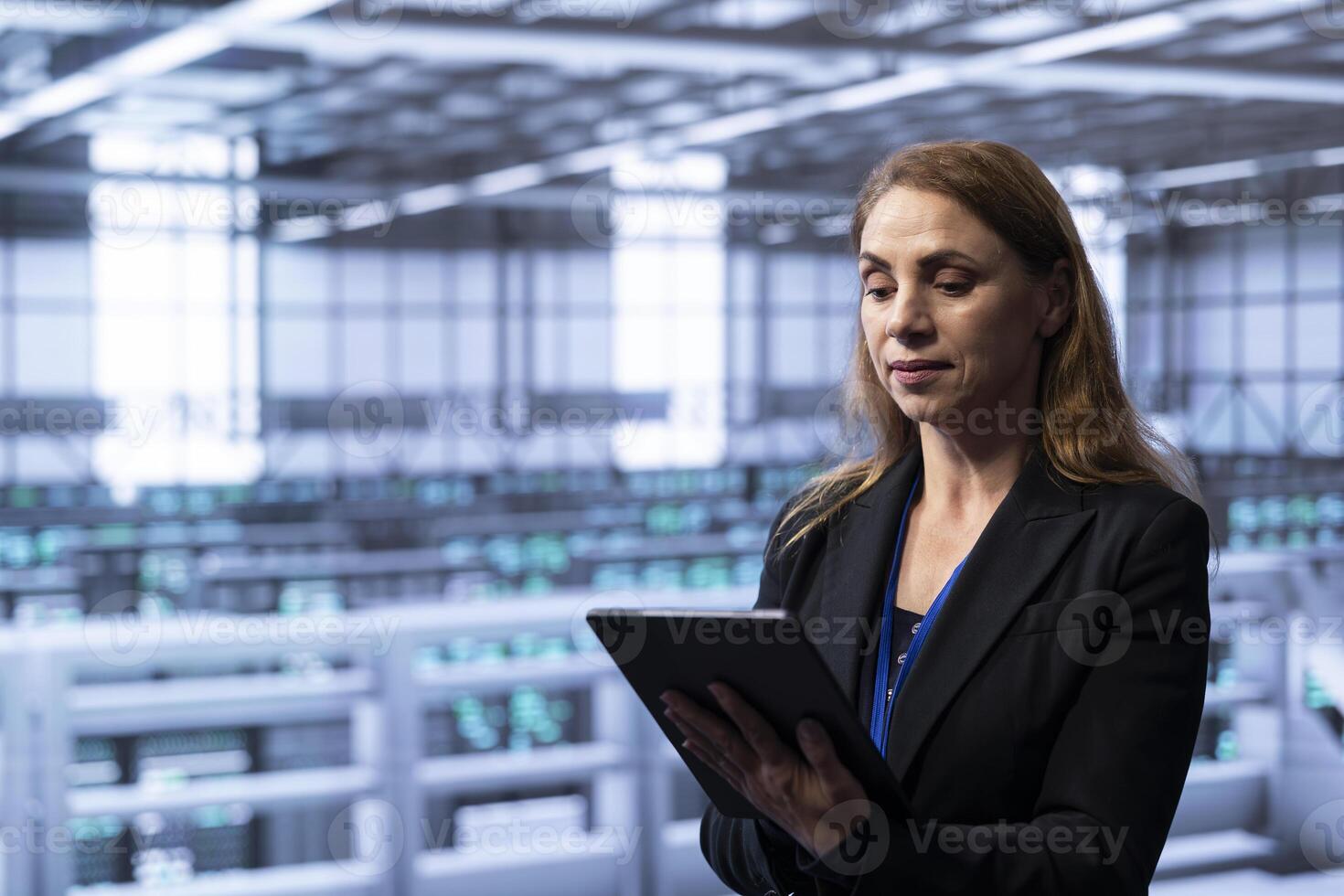 Technician in server hub checking recovery plan on tablet, monitoring energy consumption across supercomputers. Woman in data center making sure rigs are functioning optimally photo
