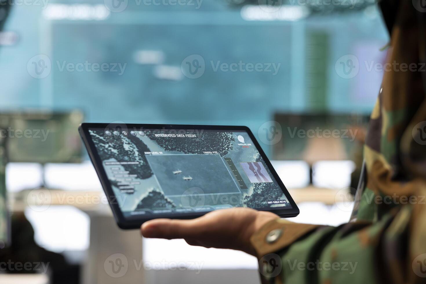 Navy operations engineer following enemy warship trajectory on CCTV radar imagery, ensuring national safety via satellite reconnaissance system on a tablet. IT general headquarters. Close up. photo
