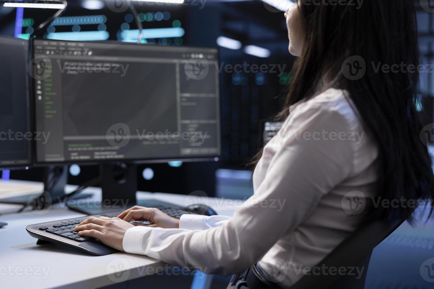 Close up shot of software developer in data center typing on keyboard, working on computer to do checkup on hardware. Woman inputting data on PC in server hub after finishing maintenance photo
