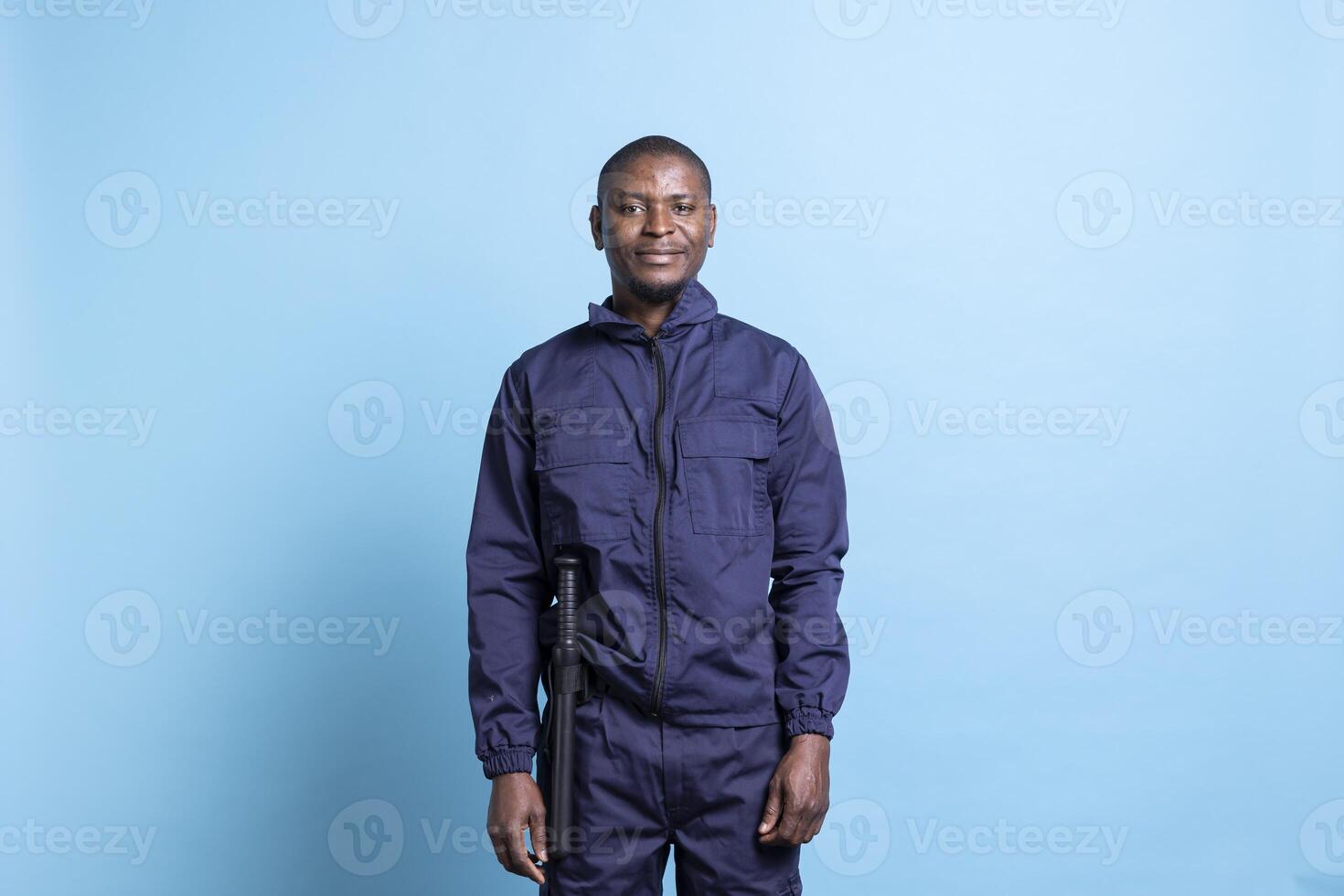 Portrait of african american security agent in uniform with baton, patrolling for order maintenance and property protection. Bodyguard on duty having huge public responsibility. photo