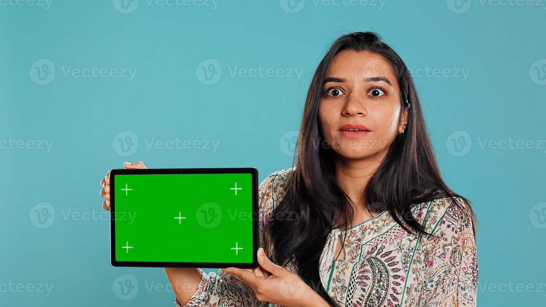Energetic salesman doing influencer marketing using green screen tablet, studio background. Lively woman reviewing product, holding empty copy space mockup digital device, camera B photo