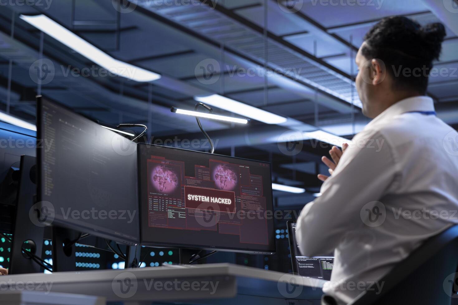 System administrator in server hub trying to protect hardware from hacker attack stealing sensitive information. Data center cybersecurity specialist fighting virus during security breach photo