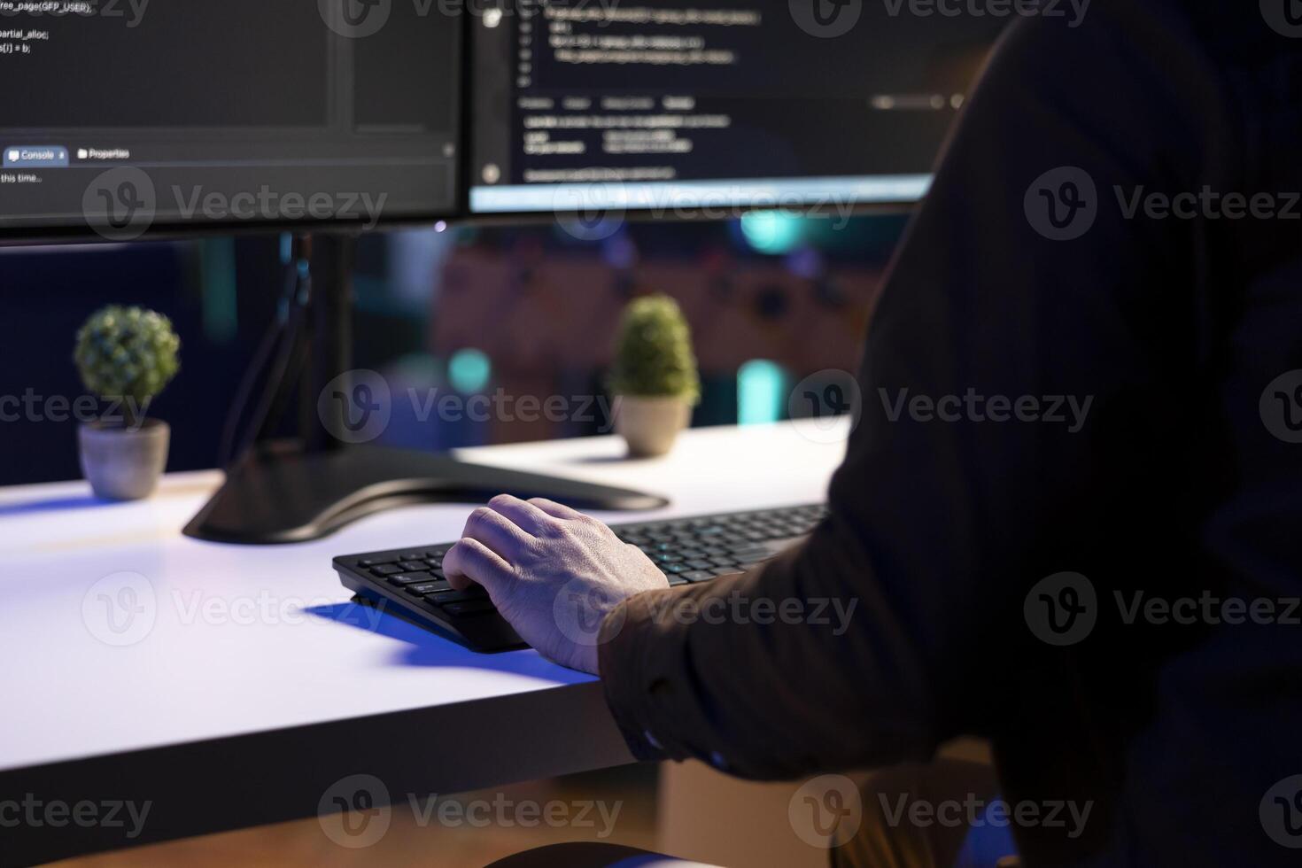 Freelancing programmer doing software debugging on computer at home, checking flaws in lines of code displayed on monitors. IT admin in apartment fixing coding issues, typing on keyboard, close up photo