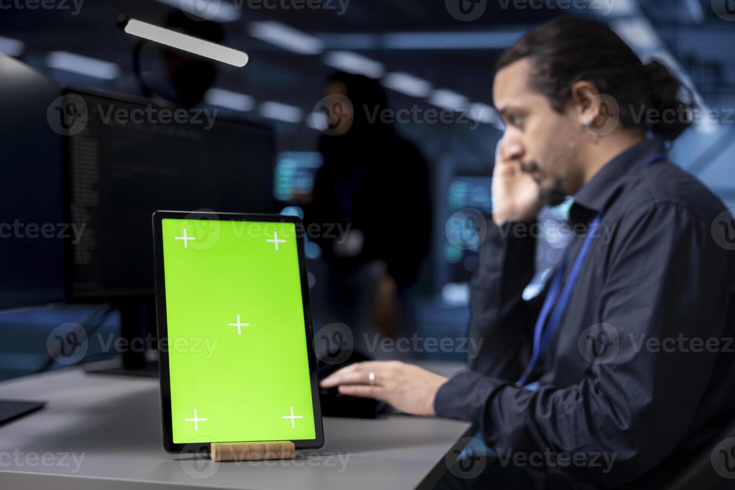 Focus on isolated screen tablet used by developer in blurry background to oversee servers used for managing databases. Close up shot of chroma key device used by IT expert in data center facility photo