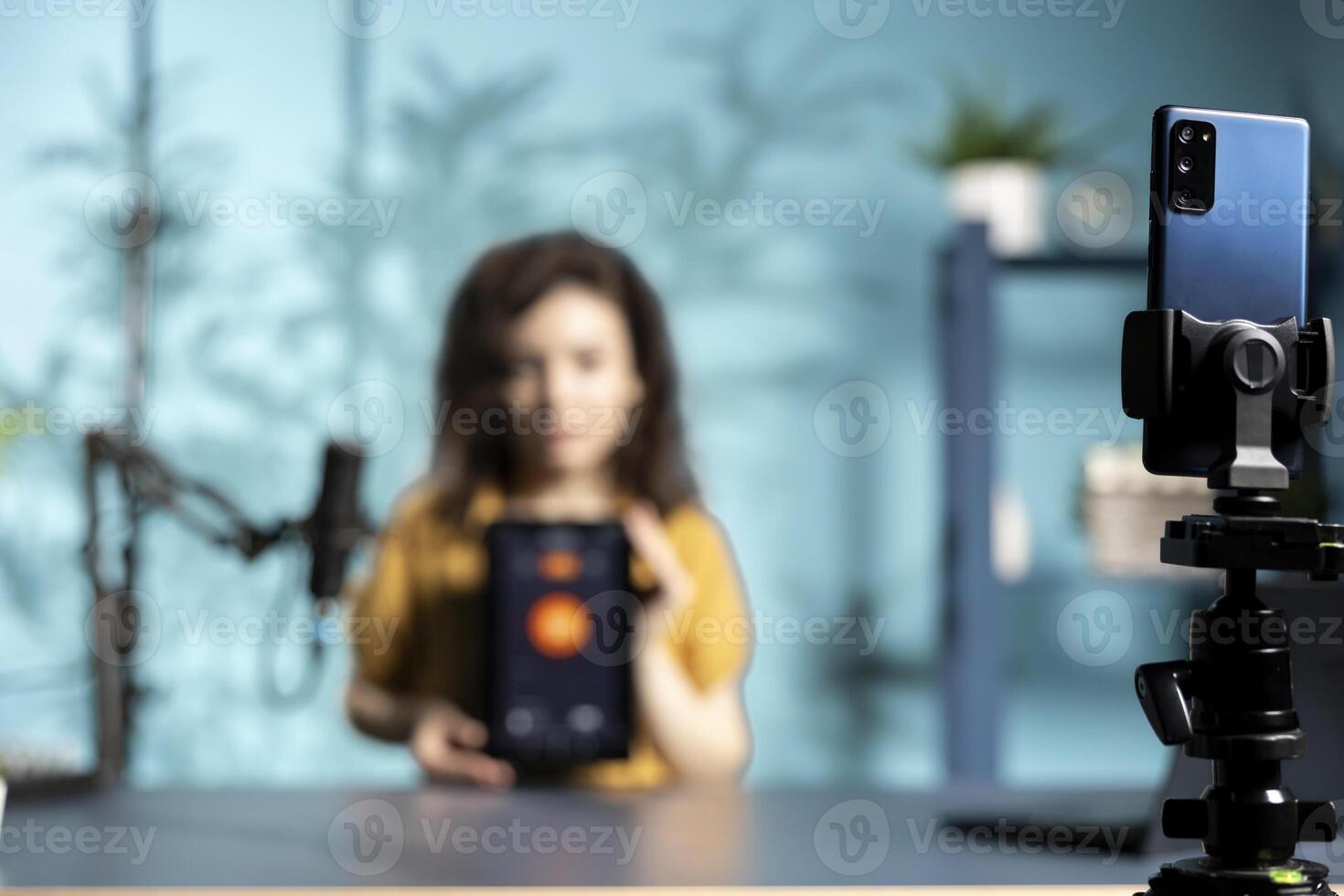 Focus on phone used by tech guru in studio to film smart light bulb tablet application presentation for online platforms. Close up of smartphone used by media star presenting IoT home automation photo