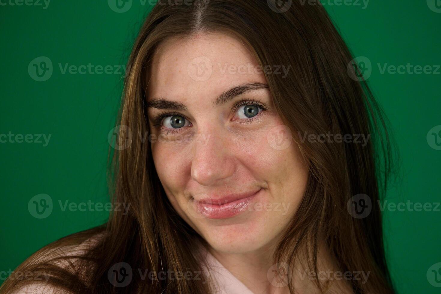 Close up face of young woman with beautiful smile isolated on grey wall with copy space. Successful multiethnic girl. Latin woman looking at camera against gray wall with a big whitening teeth smile. photo