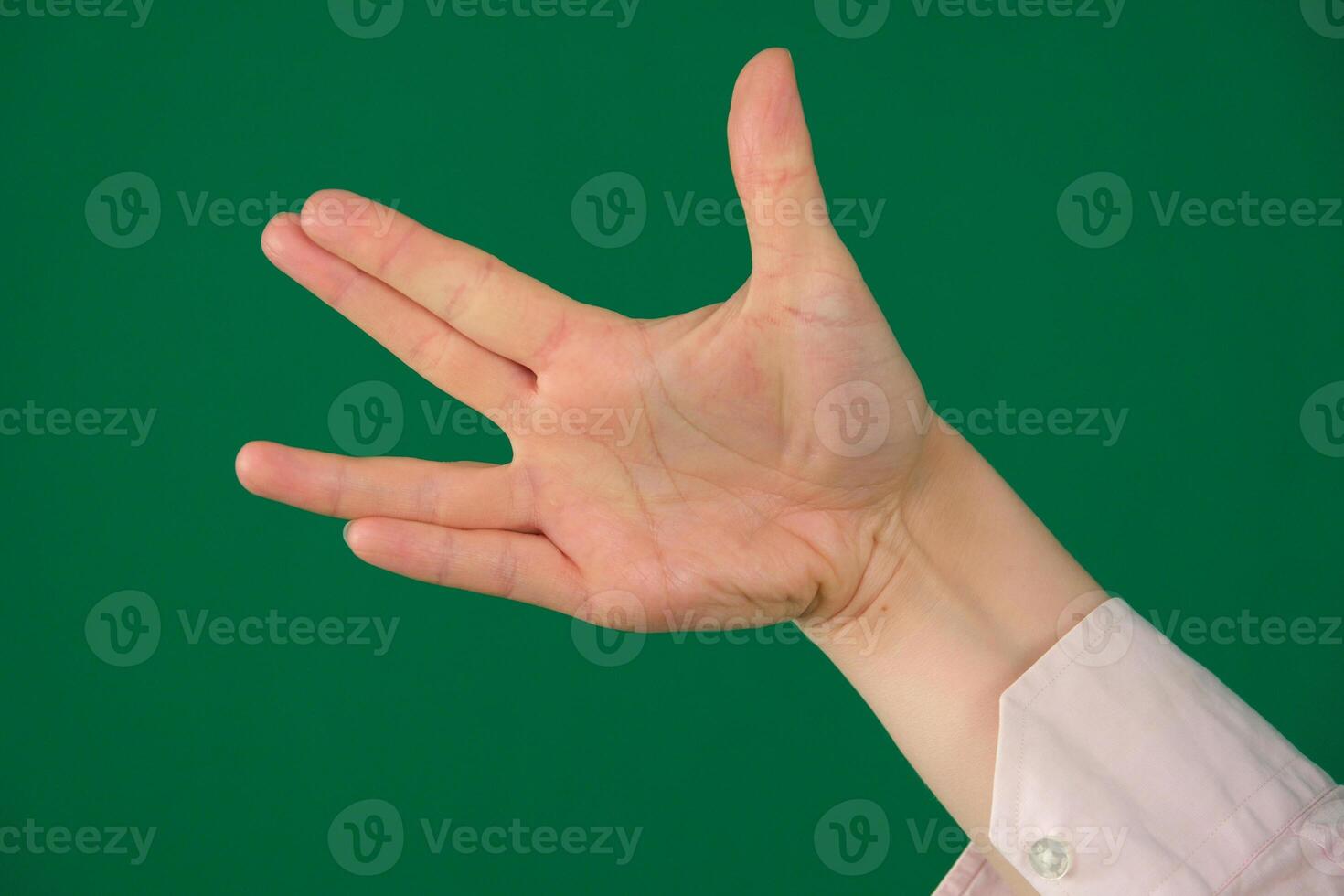 Vulcan greeting, womans hand, isolated on green photo