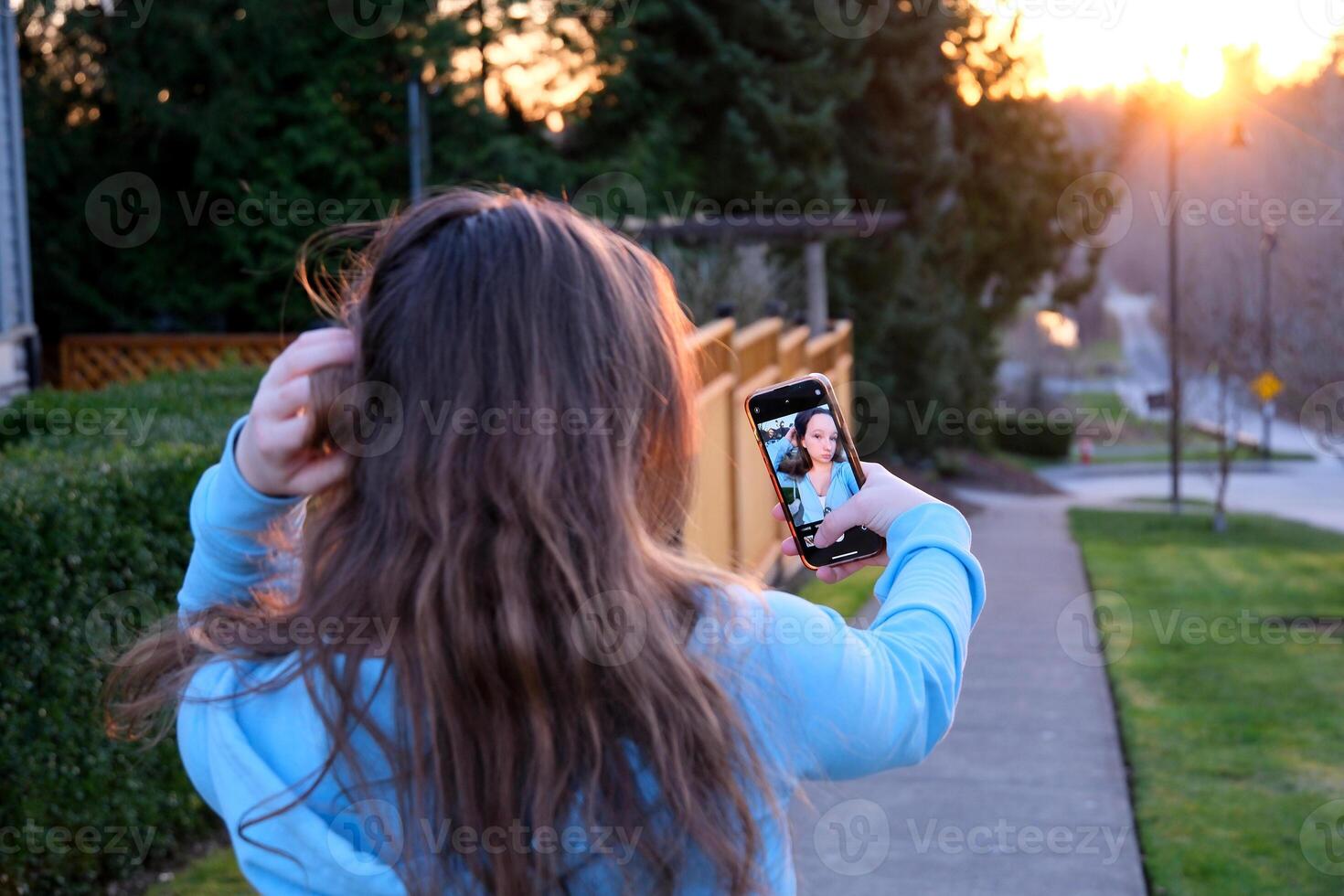 Smiling happy Indian Arabian woman female lady girl blogger influencer traveler tourist taking selfie photo on mobile phone camera travel blog for social media holidays vacation trip in city outdoors