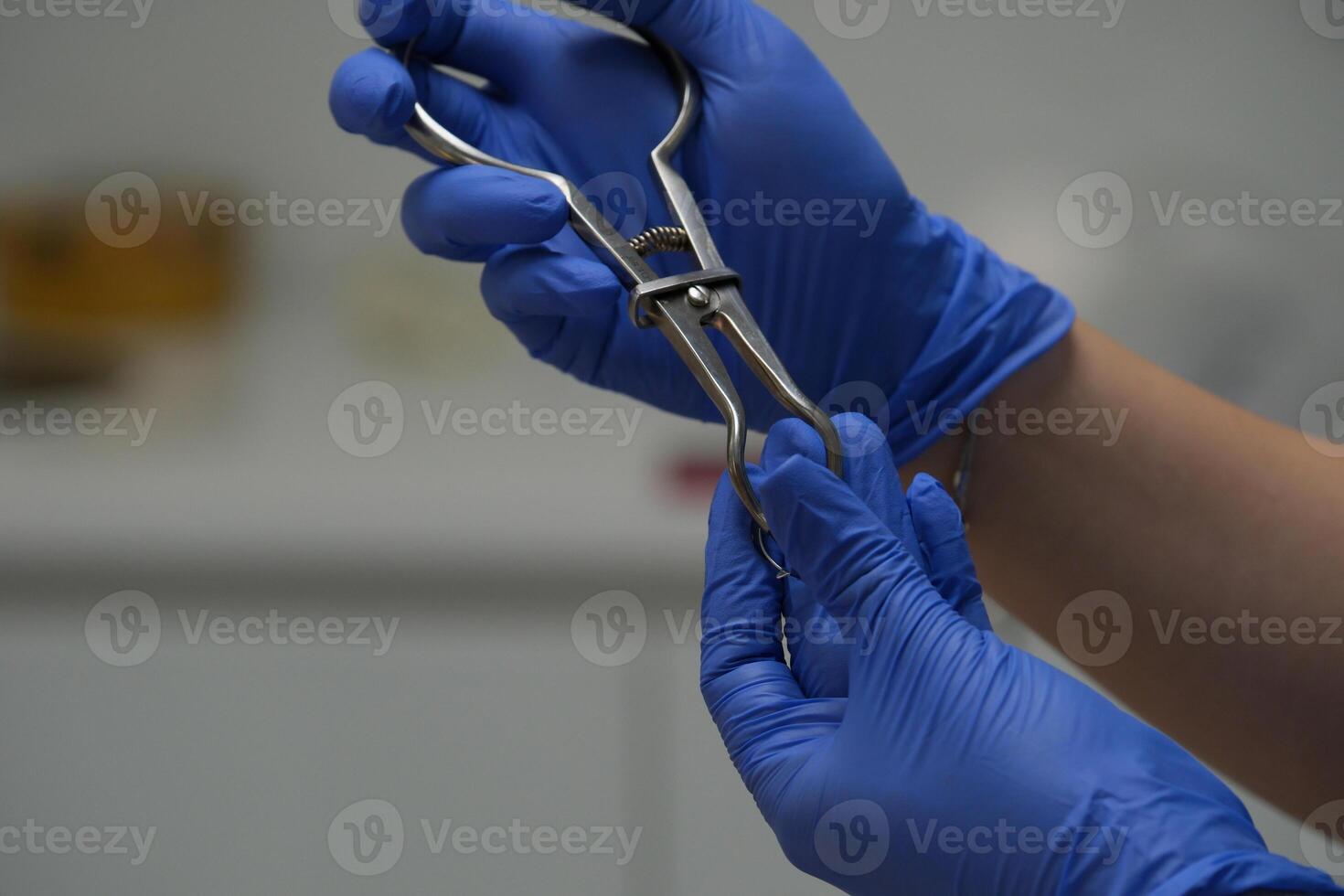 Scalpel in the hands of doctor in gloves isolated on white background. Surgeon with knife before surgery photo