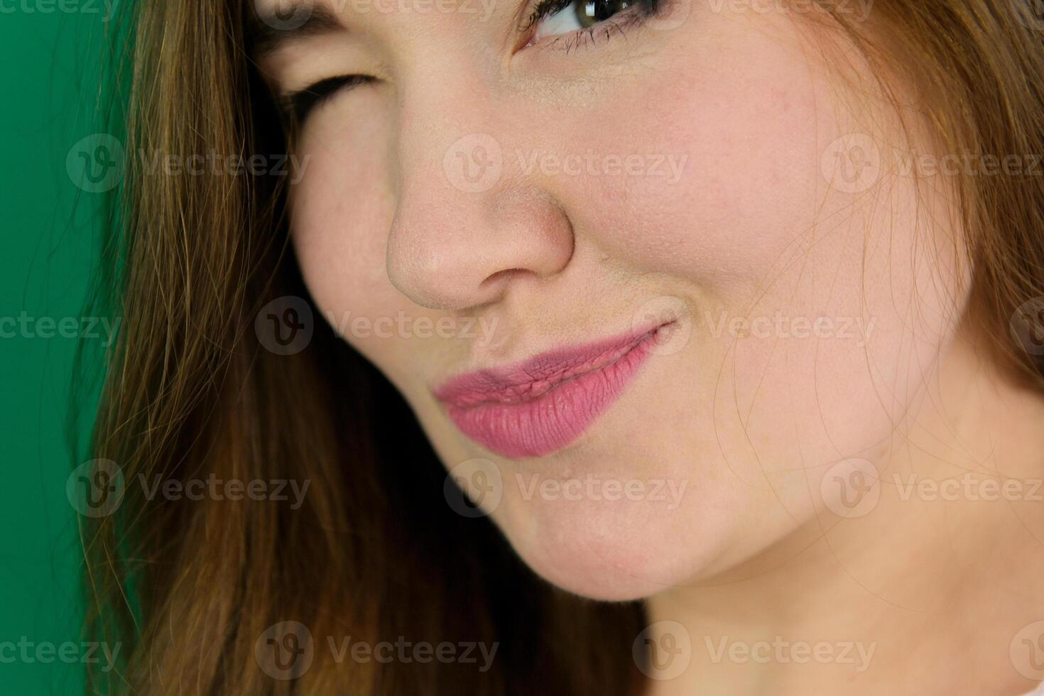 Skincare and beauty. Close up of smiling young woman winking at camera, touching shiny healthy skin, nourished face after tea tree and lemon facial serum and moisturizer,background. photo
