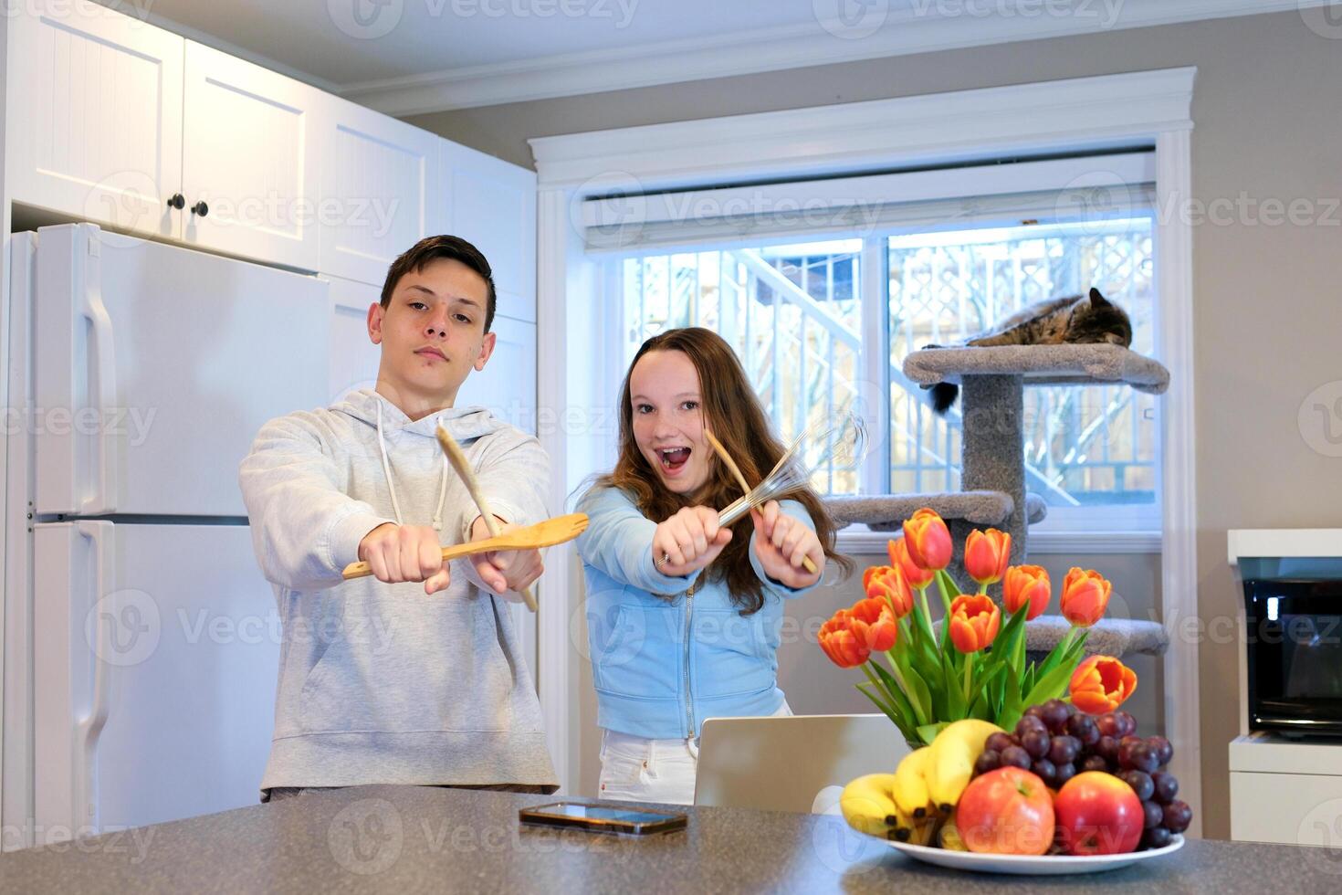 A husband wears an apron while cooking dinner with his wife. The duo took a break to sip coffee and sample the completed bread. photo