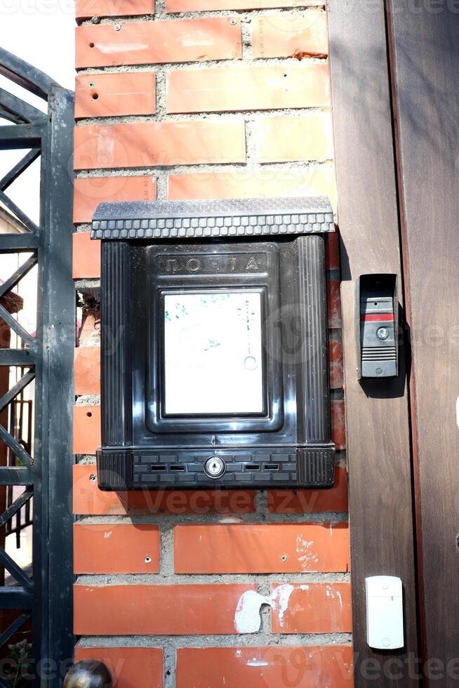 Metal mailbox with the inscription mail in Russian and intercom with a bell at the entrance door photo