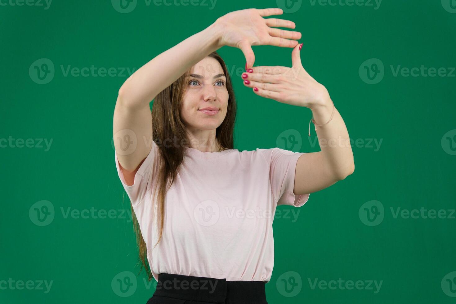 Smiling young woman hides face makes frame gesture takes photo keeps palm over eyes being in good mood wears casual white poloneck isolated over purple background captures moment pictures future