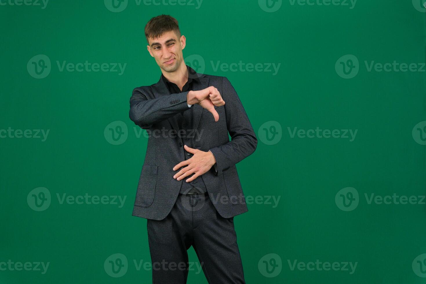 Young dissatisfied displeased sad caucasian man he wear light purple t-shirt casual clothes showing thumb down dislike gesture isolated on plain yellow background studio portrait. Lifestyle concept photo
