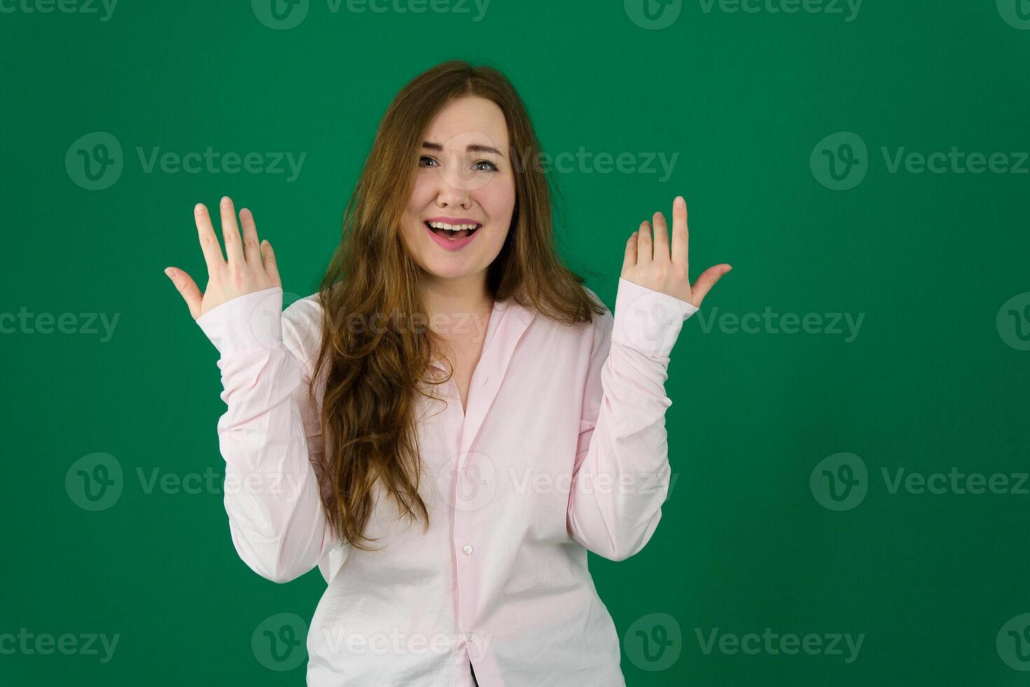 Photo of cheerful beautiful young woman standing isolated over white wall background. Looking camera showing winner gesture.
