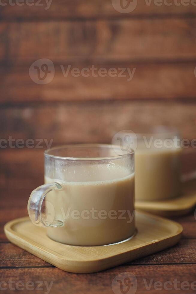 Enjoy a warm cup of coffee served in glass mugs on a rustic wooden background photo