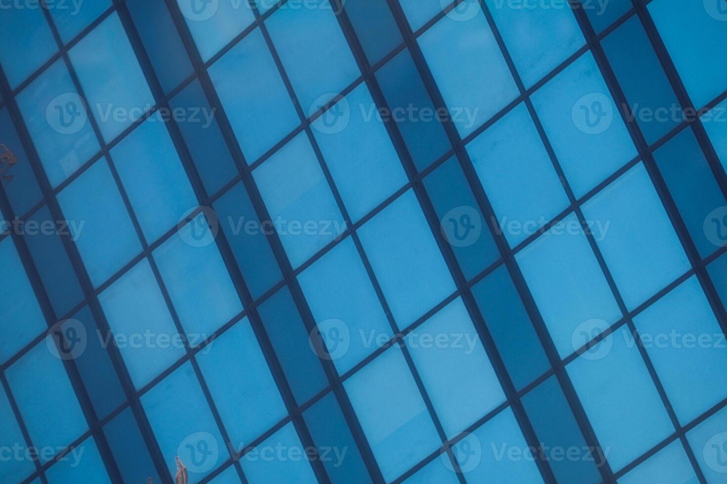 A modern office building facade with large glass windows that reflect its surroundings photo
