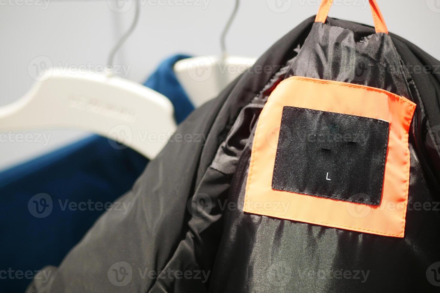 A fashionable and stylish black jacket that features a unique tag detail photo