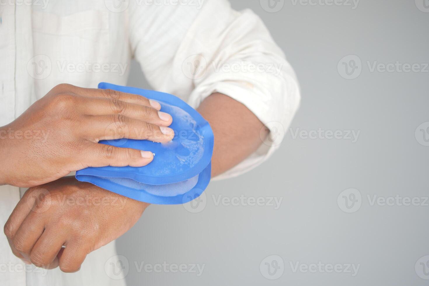 Person Applying Blue Ice Pack to Their Arm for Pain Relief or Injury photo