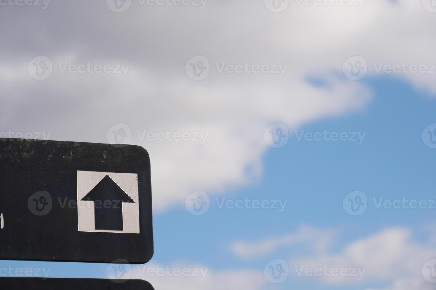 This is a Directional Sign on a Clear Day with Beautiful Clouds Above photo