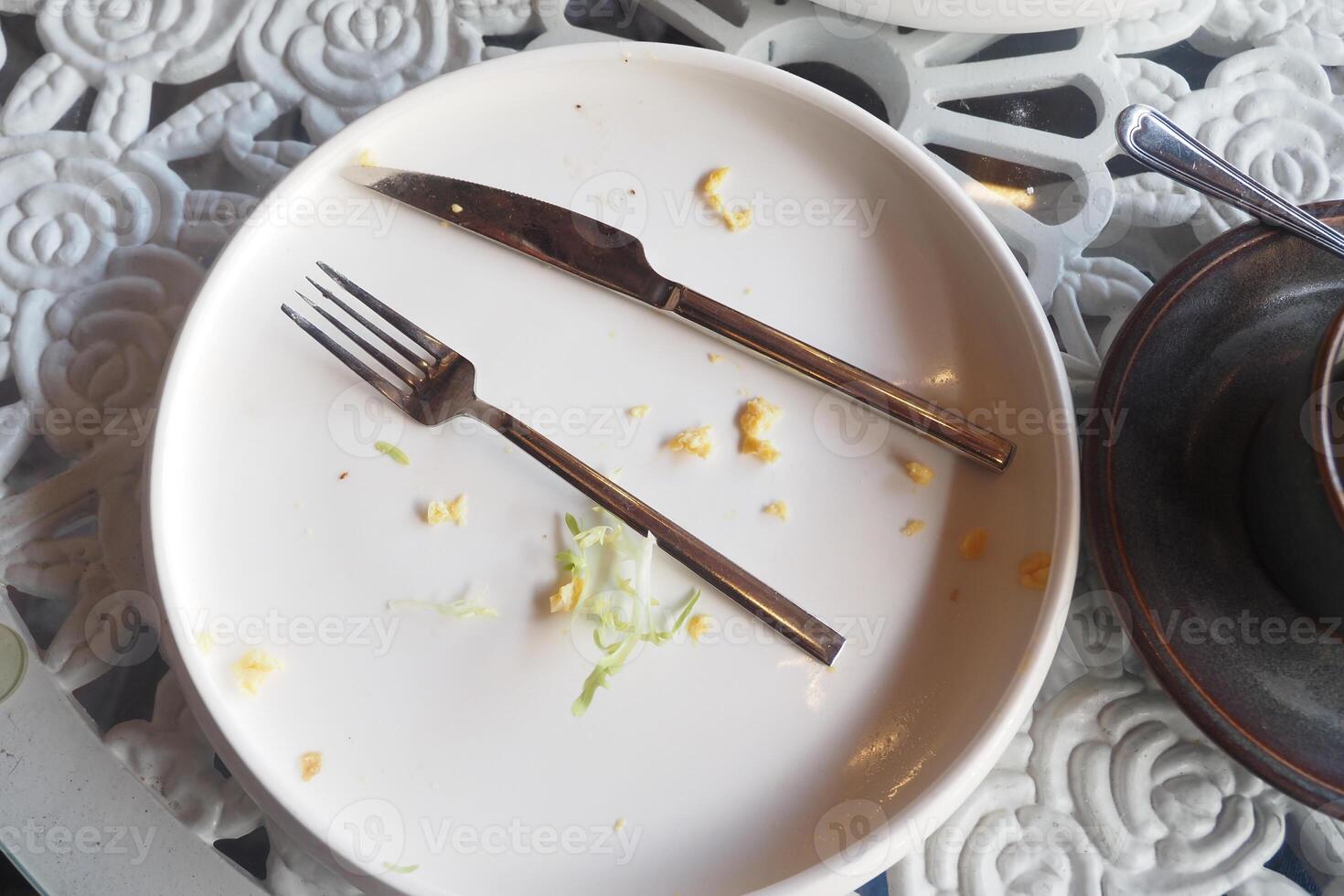 An empty plate with a spoon rests after a delicious, satisfying meal has been enjoyed photo