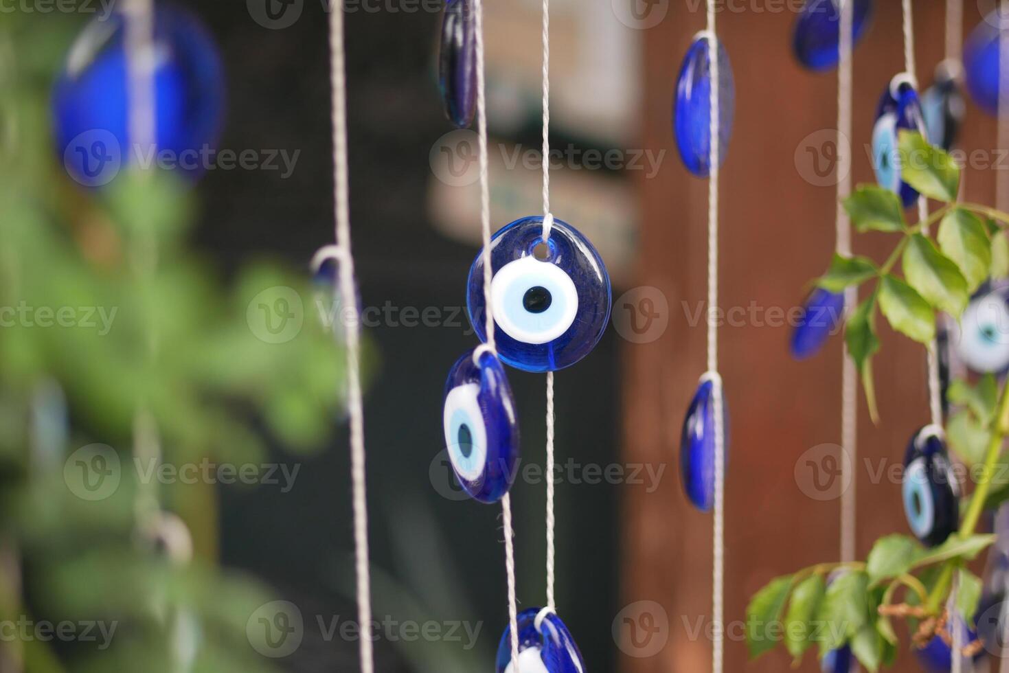 a bunch of blue evil eye keychains hanging on a shelf photo