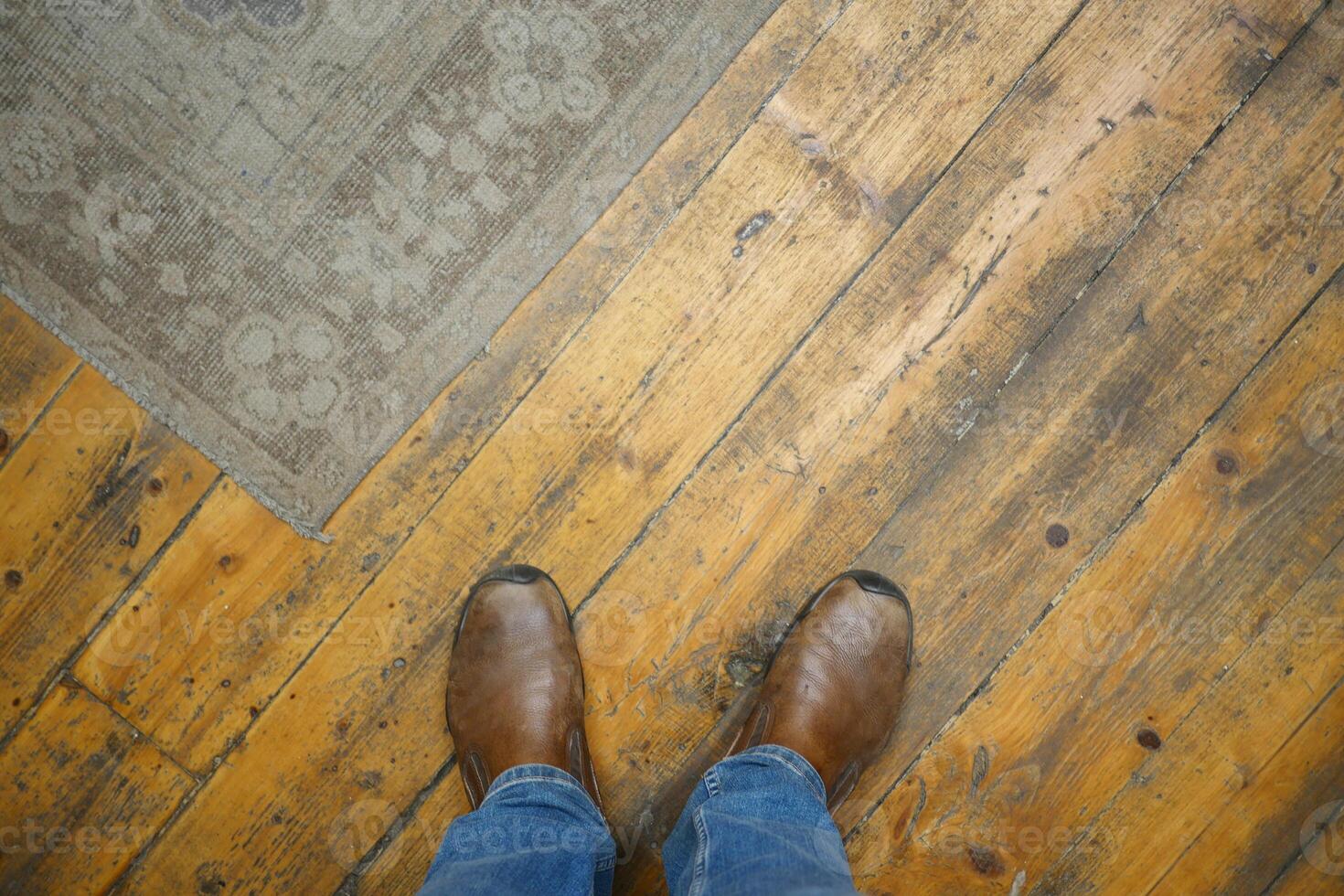 Stylish Brown Boots Placed on a Beautiful Wooden Floor and Cozy Rug photo
