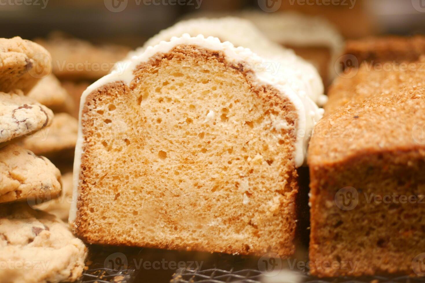 A Freshly Baked Loaf Cake Adorned with Icing and Accompanied by Cookies photo