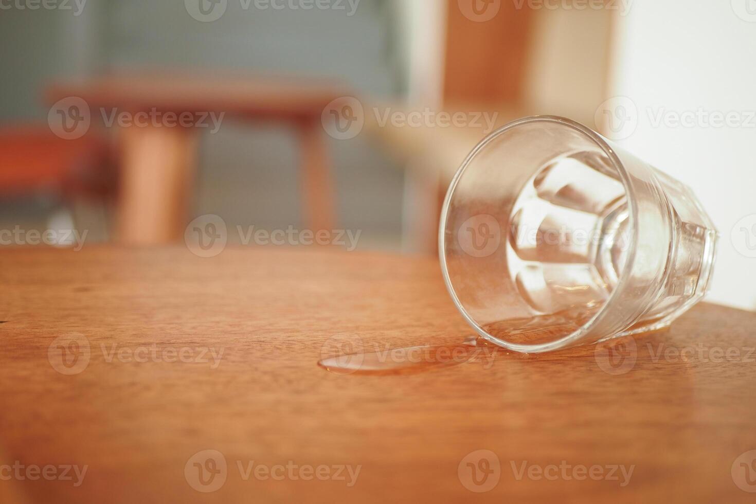 A glass has been accidentally spilled on a polished wooden table surface photo