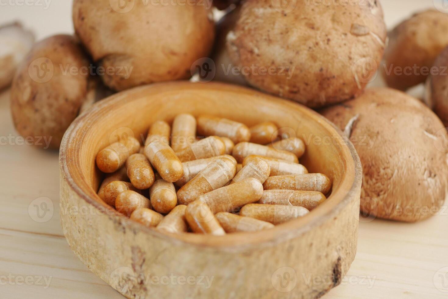 Close-Up of Mushroom Capsules and Fresh Mushrooms on a Wooden Surface photo