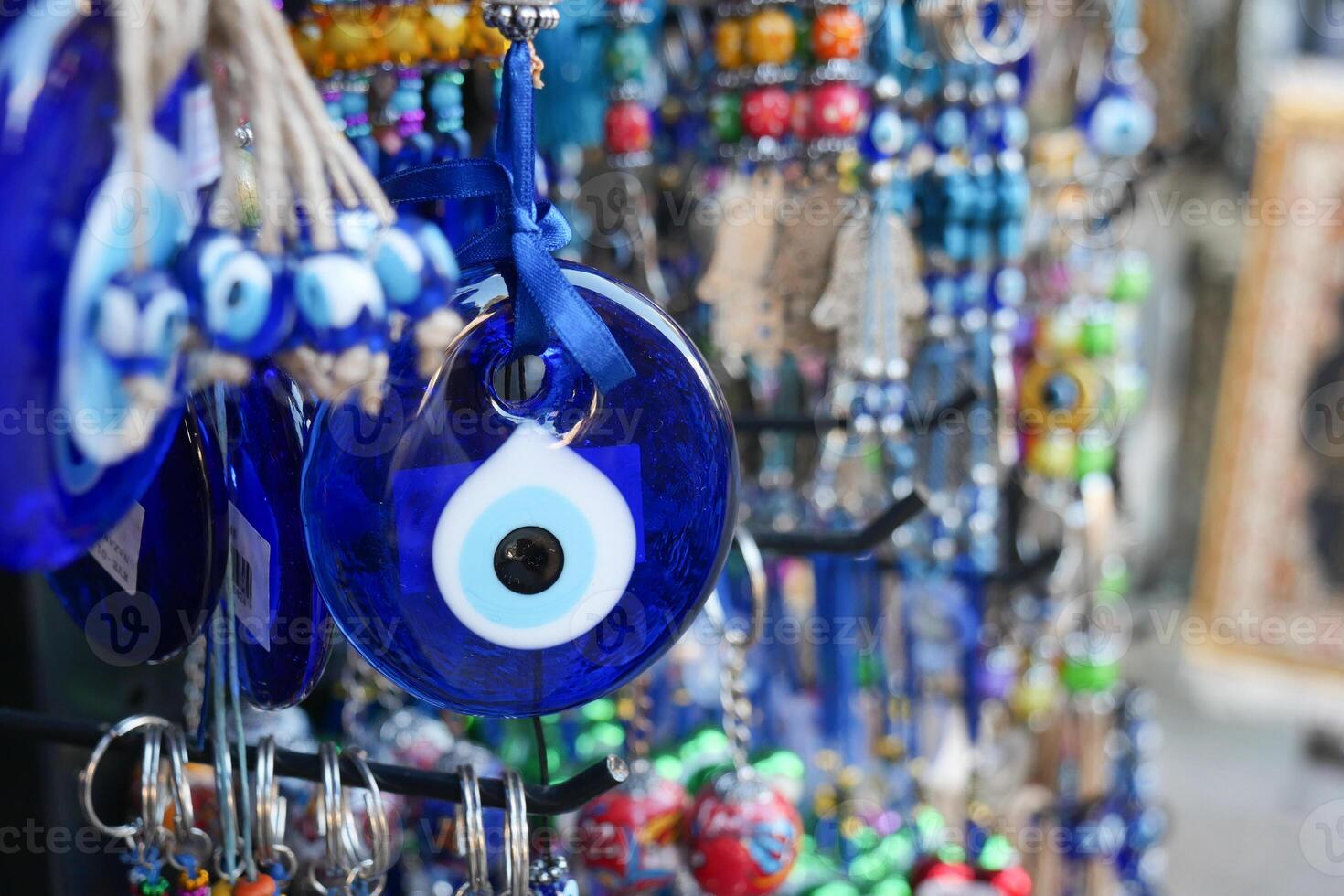 a bunch of blue evil eye keychains hanging on a shelf photo